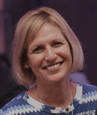 a smiling woman in a blue and white shirt